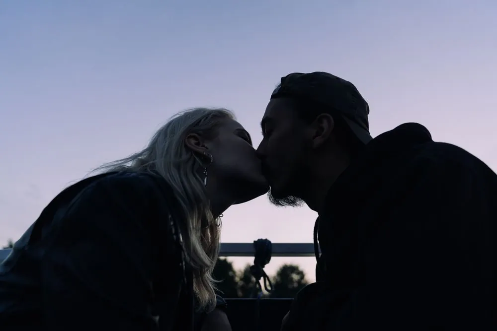 Silhouette of a couple kissing at twilight, creating a romantic and intimate mood.